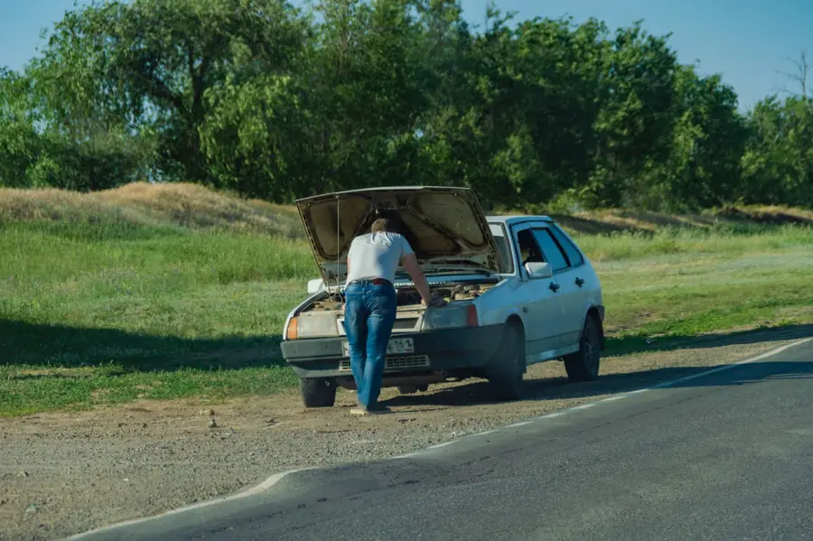 Șofer rămas în pană pe marginea drumului, cu capota ridicată